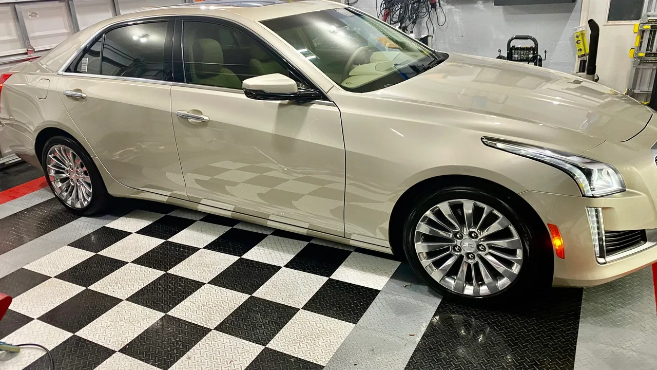 A white car parked on top of a checkered floor.