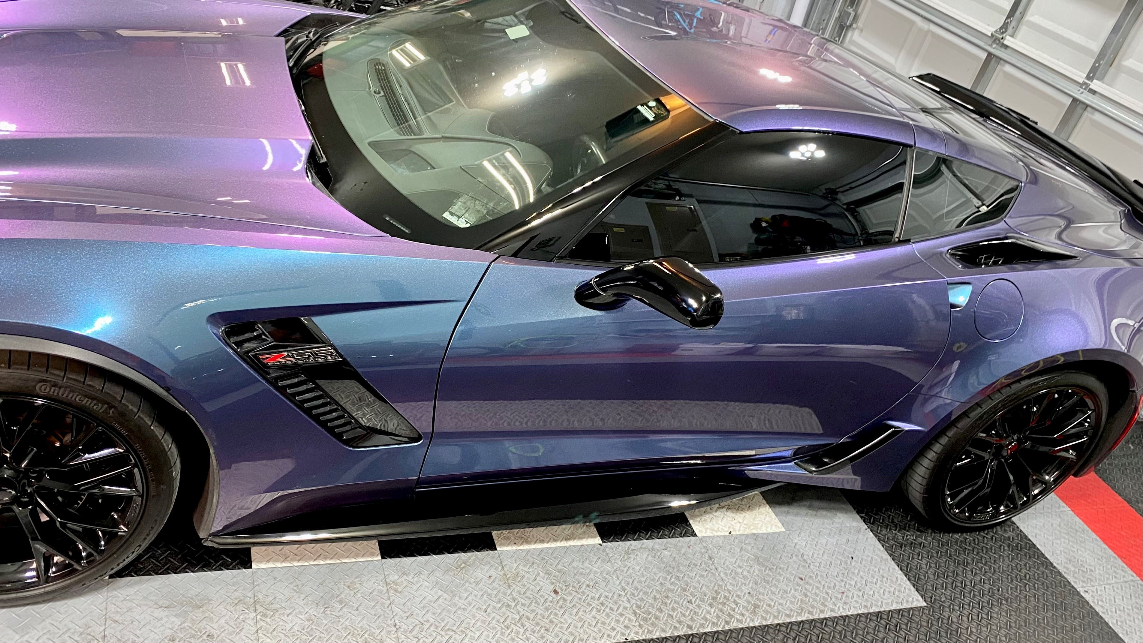 A purple sports car parked in the street.