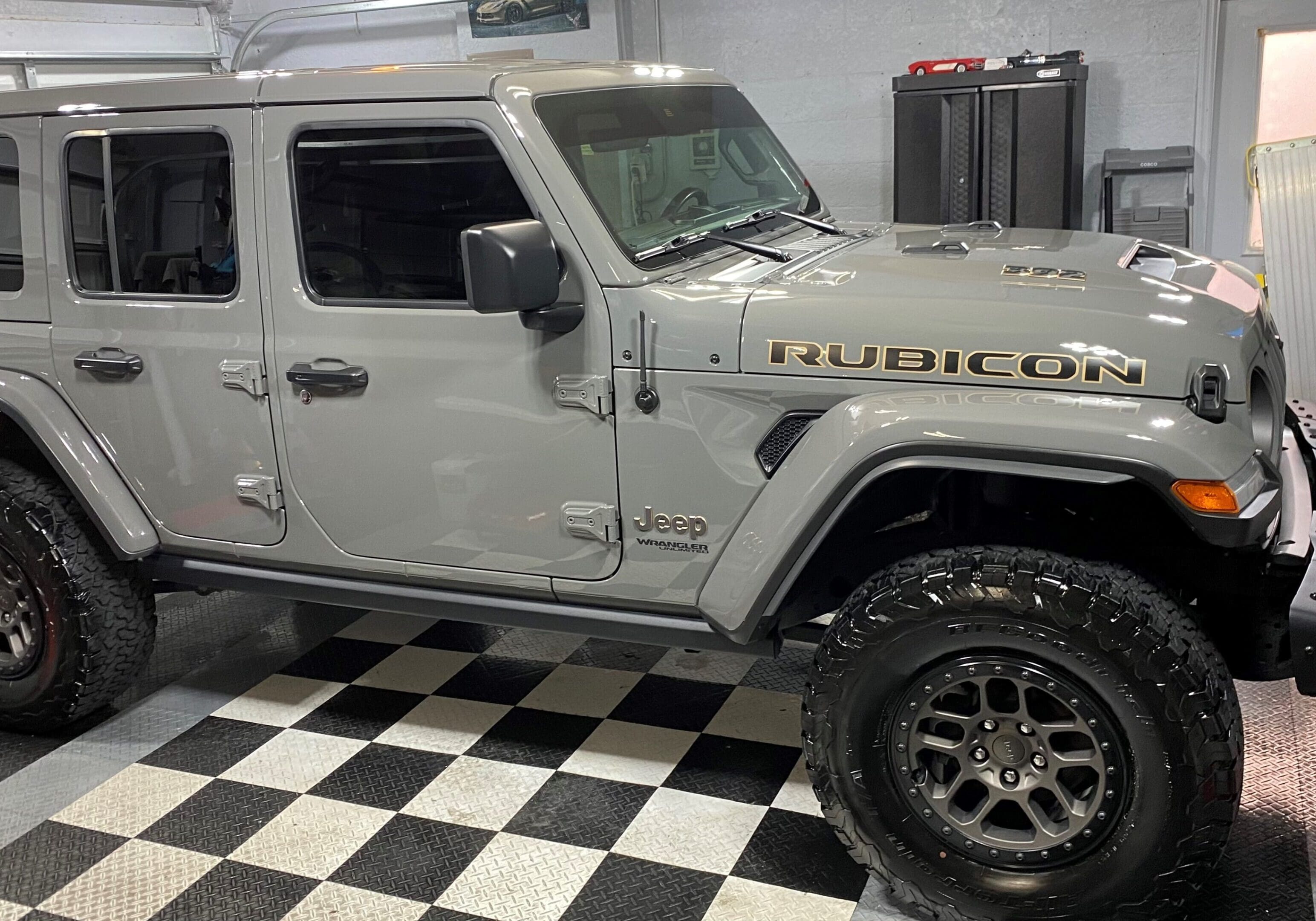 A jeep parked in a garage with checkered floor.